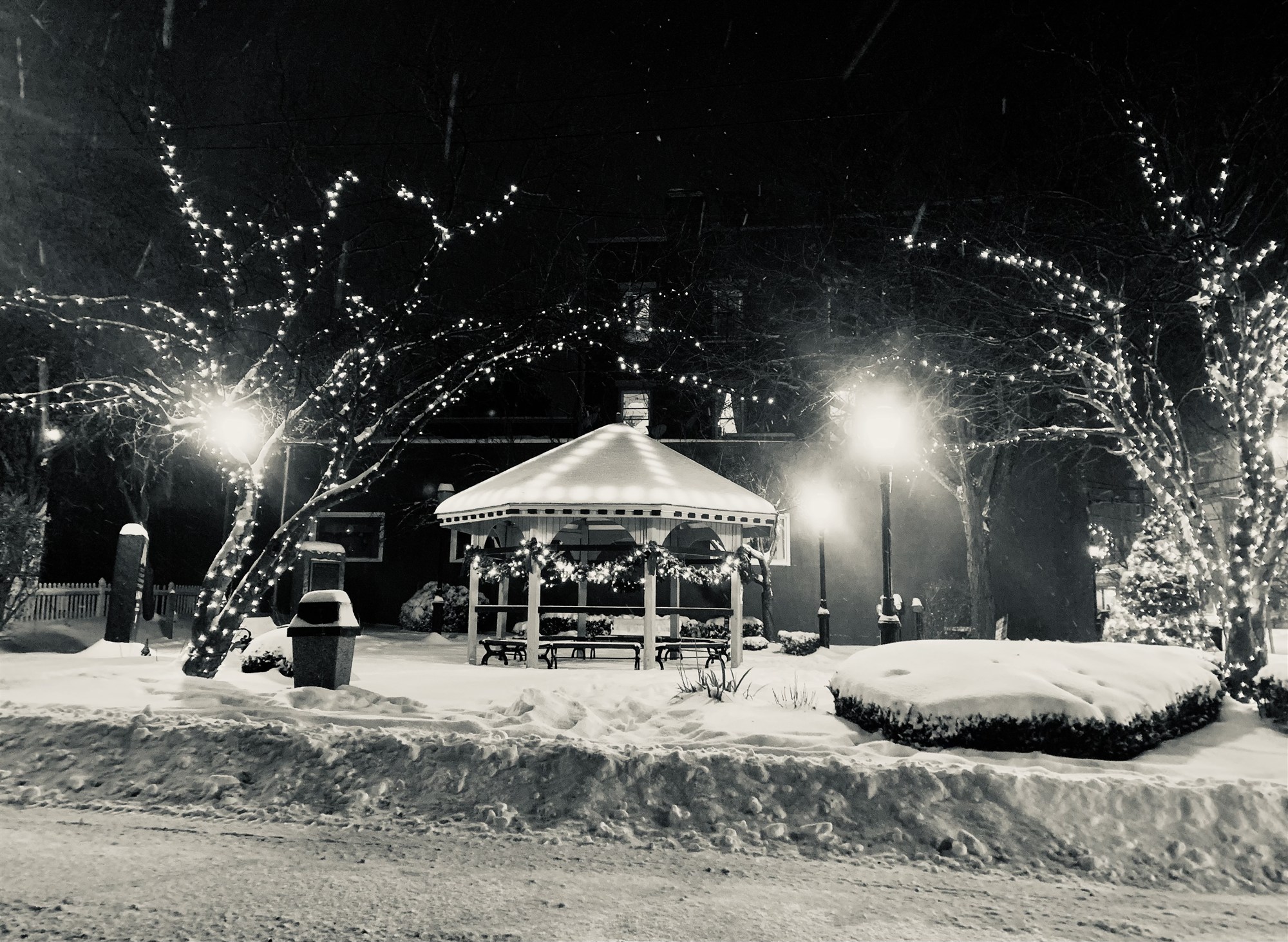 The town gazebo glowing on a snowy night.