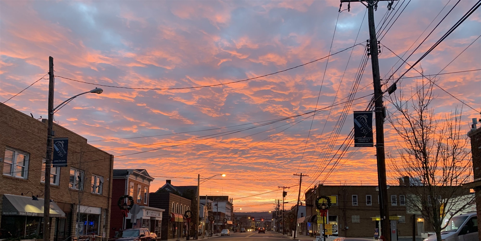 Main Street at dawn under an orange and pink sky.
