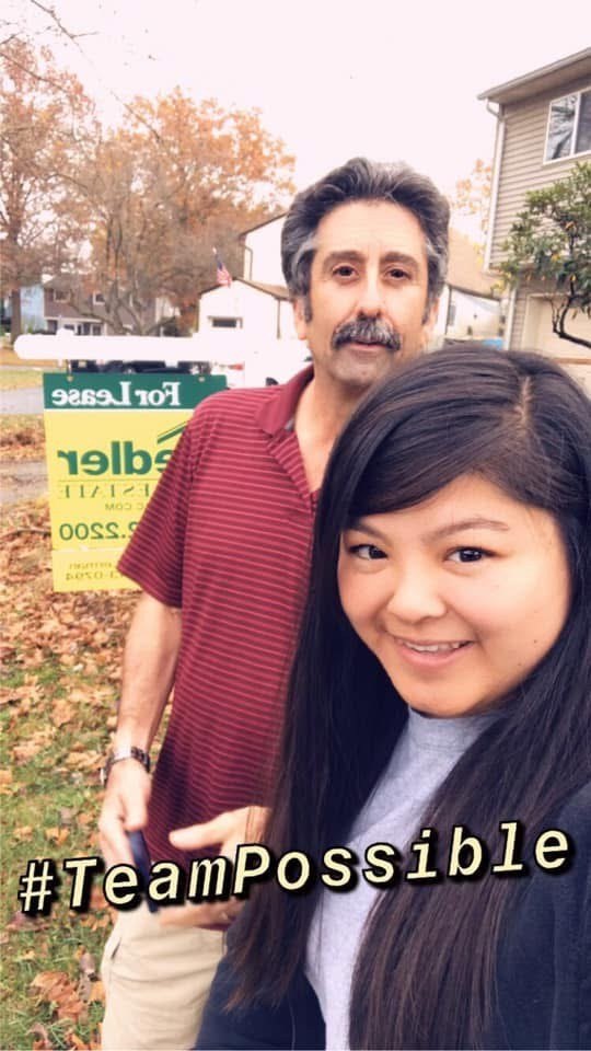 A selfie of Cynthia Cheng with William Lerman on a leaf-strewn lawn, a Fiedler For Lease sign mirrored by the front camera behind them, captioned hashtag TeamPossible.