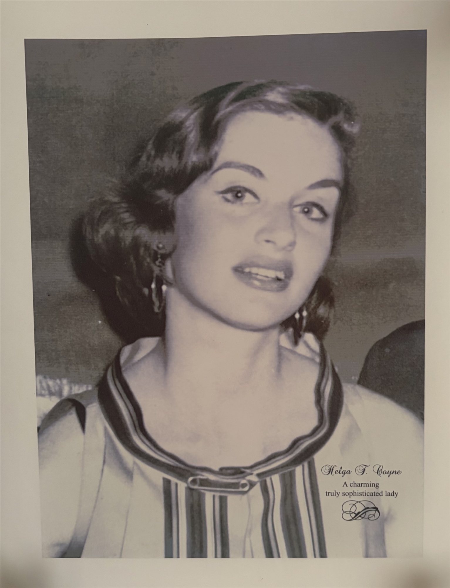 A black-and-white portrait of a young Helga Coyne with dark styled hair and drop earrings, glancing to the side.