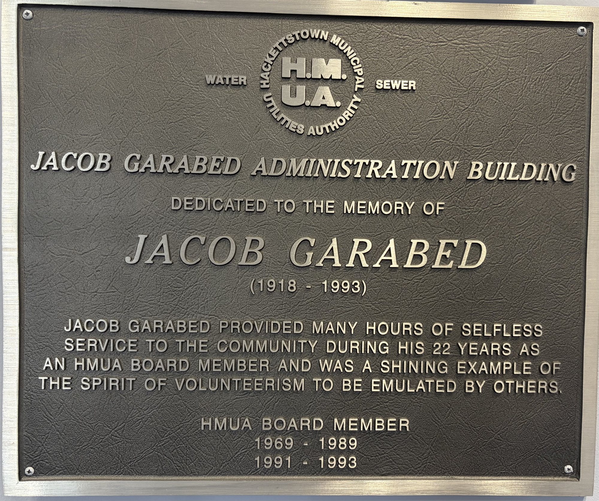 A bronze plaque dedicating the building to the memory of Jacob Garabed, 1918–1993, honoring his 22 years as an HMUA board member.