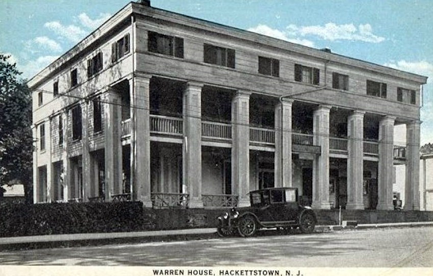 A vintage postcard of the Warren House in Hackettstown, New Jersey: a large white Greek Revival building with a two-story colonnade of square columns, and a 1920s car parked in front.